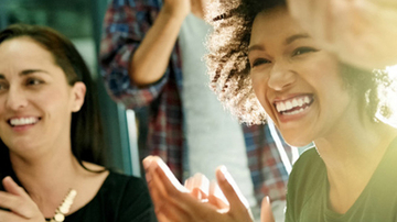 Two women clapping and smiling