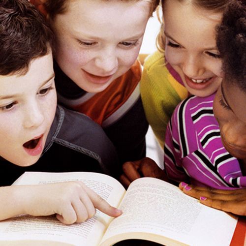 quatre enfants lisant un livre ensemble